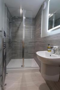 a bathroom with a shower and a sink and a tub at Firs Farm B&B in Masham