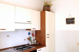 uma cozinha com armários brancos e um fogão em Le Maree Fede em Rio Marina
