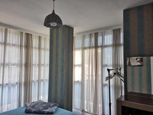 1 dormitorio con ventanas, 1 cama y lámpara de araña en Vacation home in Gonio, en Gonio