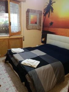 a bedroom with a bed with two towels on it at Villa Aurora in Ognina