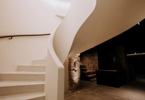 a spiral staircase in a room with a stone fireplace at Exmo Hotel by Olivia in Porto