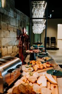 a buffet with bread and food on a table at Exmo Hotel by Olivia in Porto