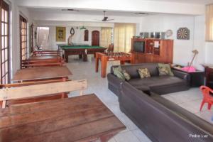 a living room with a couch and a pool table at Hotel Halloween Inn Penedo in Penedo