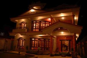 una casa grande por la noche con luces encendidas en Vardan Resort n' Apartment en Pokhara