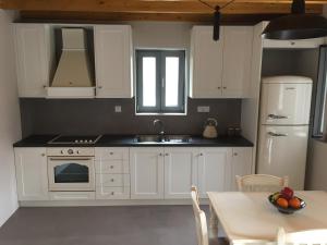 a kitchen with white cabinets and a sink and a table at Loukia in Kondiás