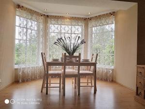 a dining room with a table and chairs and windows at Brālēni in Tūja