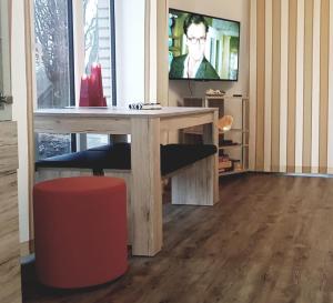 uma sala de estar com uma mesa de madeira e uma televisão em Ferienwohnung Ostseepalast em Timmendorfer Strand