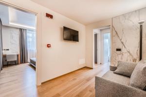 a living room with a couch and a television at Resort Miramonti in Forte dei Marmi