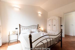 een slaapkamer met een groot bed met witte lakens bij Villa Vitto - Sleep & Go in Capoterra