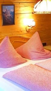 1 Schlafzimmer mit 2 Betten mit rosa und weißer Bettwäsche in der Unterkunft Almbrünnerl die Almhütte auf der Raffner Alm in Ruhpolding