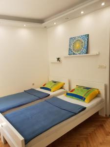 dwa łóżka w pokoju z obrazem na ścianie w obiekcie Apartment Split w Splicie