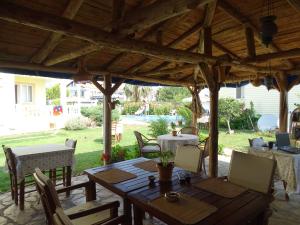 een patio met een tafel en stoelen onder een houten pergola bij Mavikosk in Dalyan