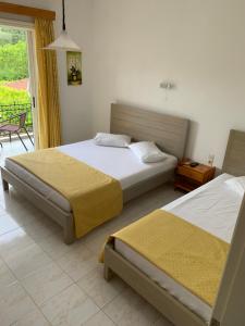 a bedroom with two beds and a table and a window at Filoxenia Kontogiannis in Lazaráta
