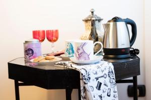 a table topped with a coffee mug and a cup of tea at Bibliò Rooms Guesthouse in Bologna