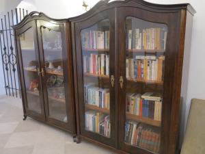 um armário de madeira com portas de vidro cheias de livros em Zámecký penzion Sloup em Sloup