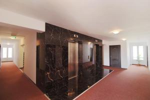 a hallway with black marble walls in a house at Complex Balnear Cerbul in Covasna
