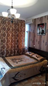 - une chambre avec un lit et un lustre dans l'établissement Kobuleti Rezidense, à Kobuleti