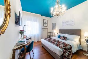 a bedroom with a large bed and a chandelier at Bibliò Rooms Guesthouse in Bologna