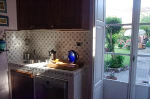 a kitchen with a counter with a sink and a window at Grand Tour Resort in Pisa +17 photos