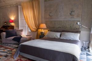 a bedroom with a large bed and a chair at Grand Tour Resort in Pisa