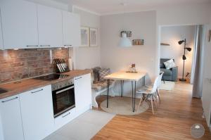 a kitchen with white cabinets and a table and a dining room at Noorden Stuuv in Wittenborn
