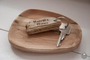 a wooden cutting board with a key on a cutting board at Noorden Stuuv in Wittenborn