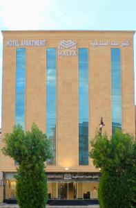 un immeuble d'appartements avec un panneau sur celui-ci dans l'établissement Malfa Hotel Apartments, à Qal'at Bishah