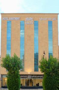 a hotel apartment building with a sign on it at Malfa Hotel Apartments in Qal'at Bishah