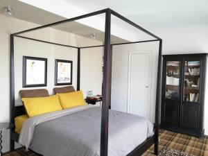 a bedroom with a canopy bed with yellow pillows at Monts Dôme in Clermont-Ferrand