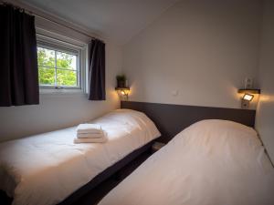 two beds in a room with a window at Luxe Lodge Zeehoeve in Harlingen