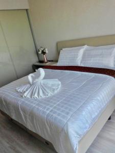 The Pine Hua Hin في هوا هين: سرير ابيض عليه بجعة بيضاء