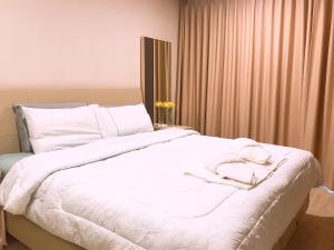 1 dormitorio con 1 cama blanca con sábanas blancas en The Pine Hua Hin, en Hua Hin