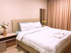 um quarto com uma cama grande e lençóis brancos em The Pine Hua Hin em Hua Hin