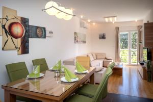 comedor con mesa de madera y sillas verdes en Apartments ViLu, en Hvar