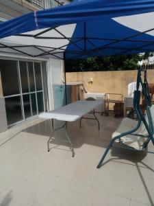 a table and a chair under an umbrella on a patio at Sheffer in Ramat Gan