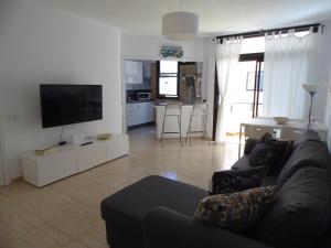salon z kanapą i telewizorem z płaskim ekranem w obiekcie Apartamento Medanero FGF w mieście El Médano