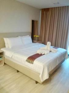 um quarto com uma cama grande e lençóis brancos em The Pine Hua Hin em Hua Hin