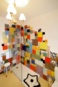 una pared de azulejos coloridos en una habitación con taburete en La Casina de Micaela, en Perales del Puerto