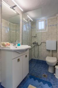 a bathroom with a toilet and a sink and a shower at Chalkidiki Beachfront Apartment in Nea Iraklia