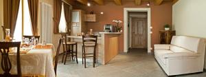 a kitchen and living room with a couch and a table at L'Abrì in Pietraporzio