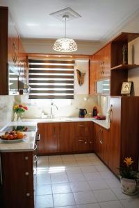 a large kitchen with wooden cabinets and a sink at Petros Garden Ηouse in Gaïtánion