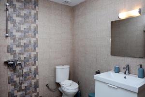 uma casa de banho com um WC, um lavatório e um espelho. em Ermioni Apartments em Nea Vrasna