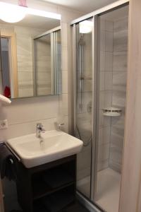 ein Bad mit einem Waschbecken und einer Dusche in der Unterkunft Apartments beim Backhäusle in Starzach