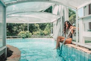 莫沙夫拉莫特Eili Suites的坐在游泳池边缘的女人
