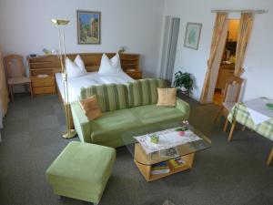 a living room with a green couch and a bed at Ferienwohnung Zechner in Velden am Wörthersee