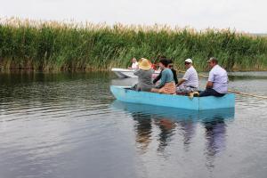 un grupo de personas en un barco azul en el agua en Sultan Pansion Bird Paradise, en Ovaciftlik