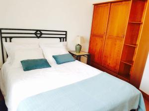 ein Schlafzimmer mit einem weißen Bett mit zwei blauen Kissen in der Unterkunft SUNSET house in Moledo