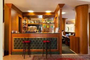 a bar with two red stools in a room at Hotel Atlantic Vista Mare in Pesaro