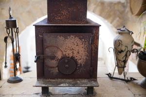 an old rusty stove sitting on a table with vases at Mikes Khan in Abū Ghaush