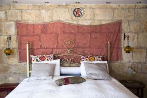 una camera con un grande letto con una parete rossa di Mikes Khan ad Abū Ghaush